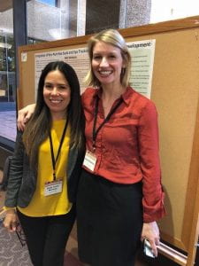 Left: Dr. Gredia Huerta-Montanez and Dr. Emily Zimmerman pose in front of Dr. Zimmerman’s poster. 